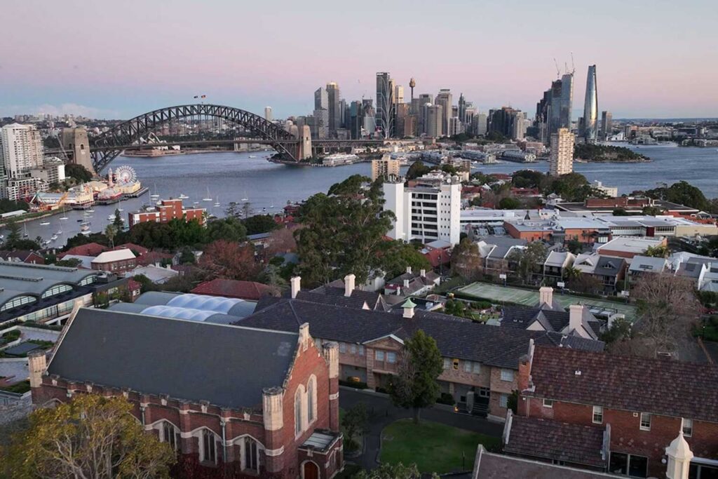 Aerial view of Shore School in North Sydney, with the Sydney Harbour Bridge and city skyline behind