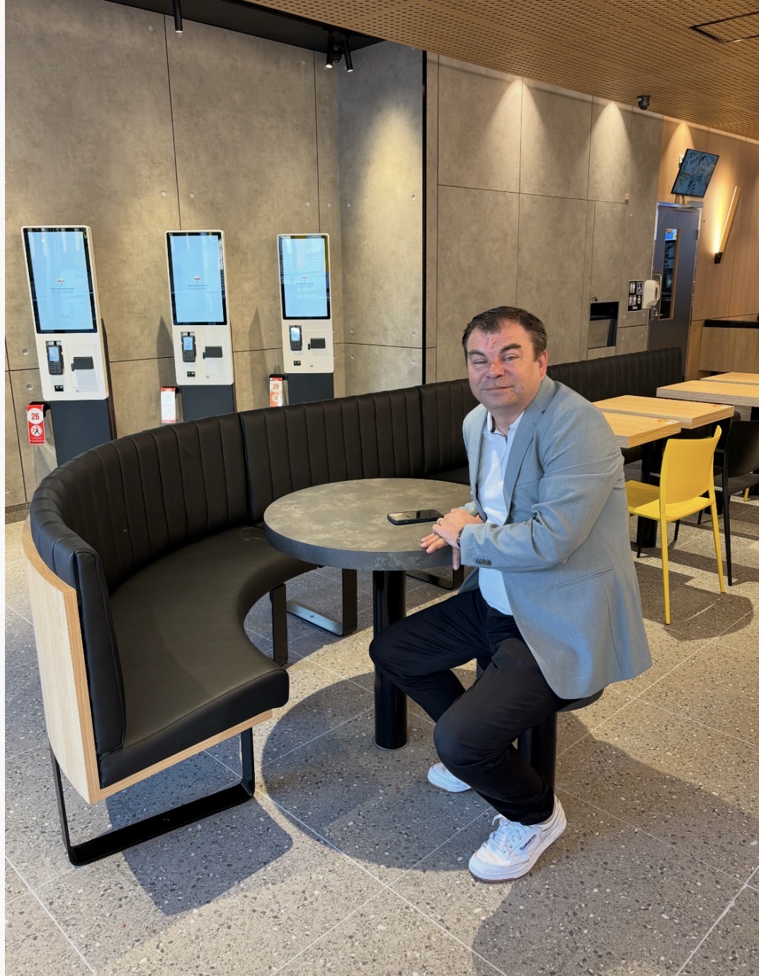 Screenshot Bernard Kelly sits beside the self-service ordering kiosks in one of his McDonald's restaurants.