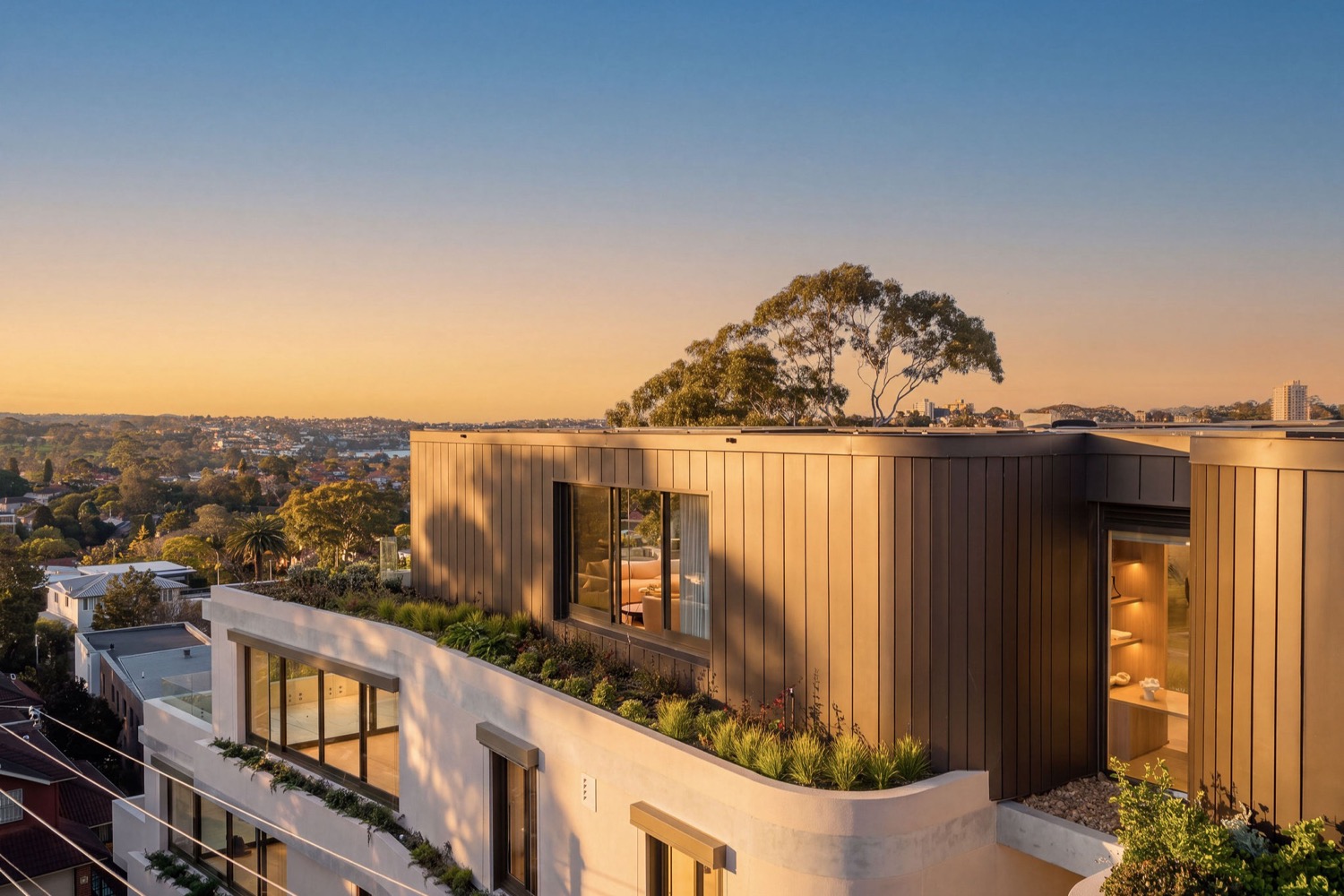 The whole-floor penthouse at Park Residences, Cremorne, at sunset, with its planted rooftop terrace and views over the Lower North Shore.