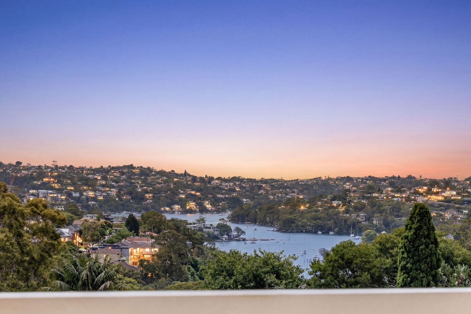 The north facing outlook from the Park Residences penthouse across Cremorne to the boats on Middle Harbour at dusk.