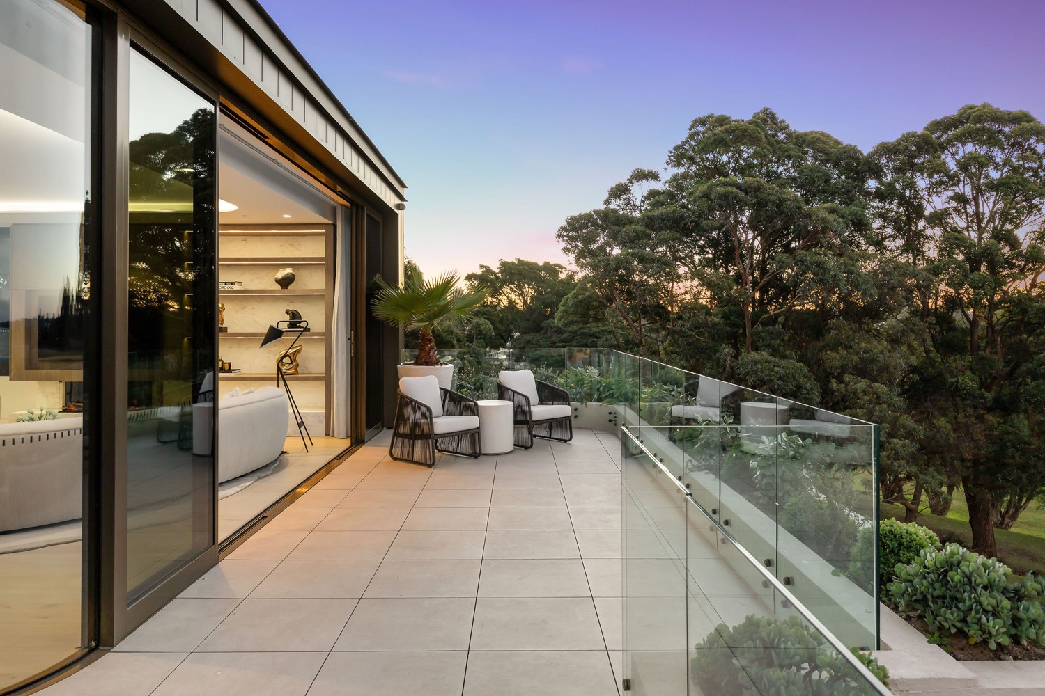 The 74sqm wraparound entertaining terrace at the Park Residences penthouse in Cremorne at dusk.