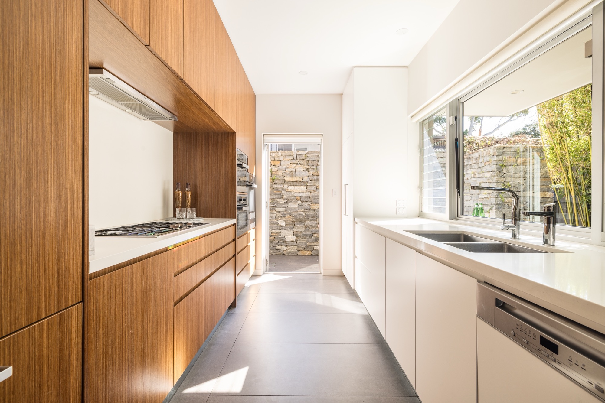 51-young-lane-cremorne-galley-kitchen-miele The galley kitchen at 51 Young Lane, Cremorne, with Miele appliances and stone benchtops.