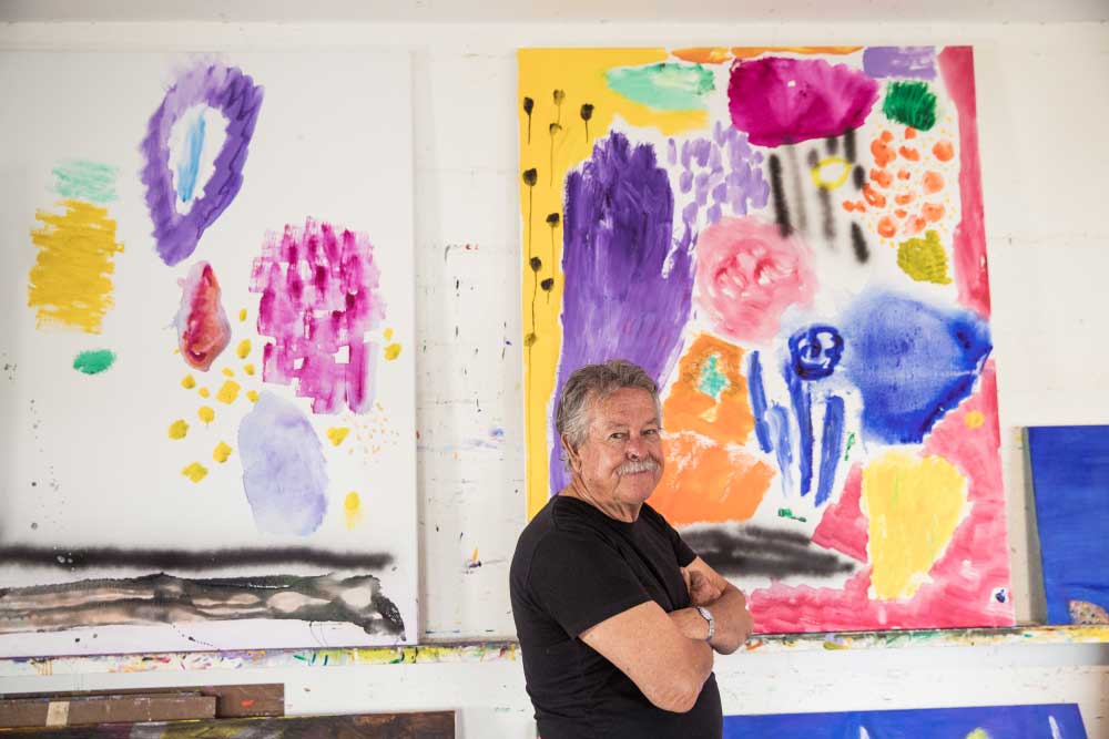 Ken Done at his art room with smile and arms folded
