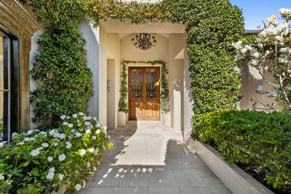 Vine-draped gardens and archways at home's entrance